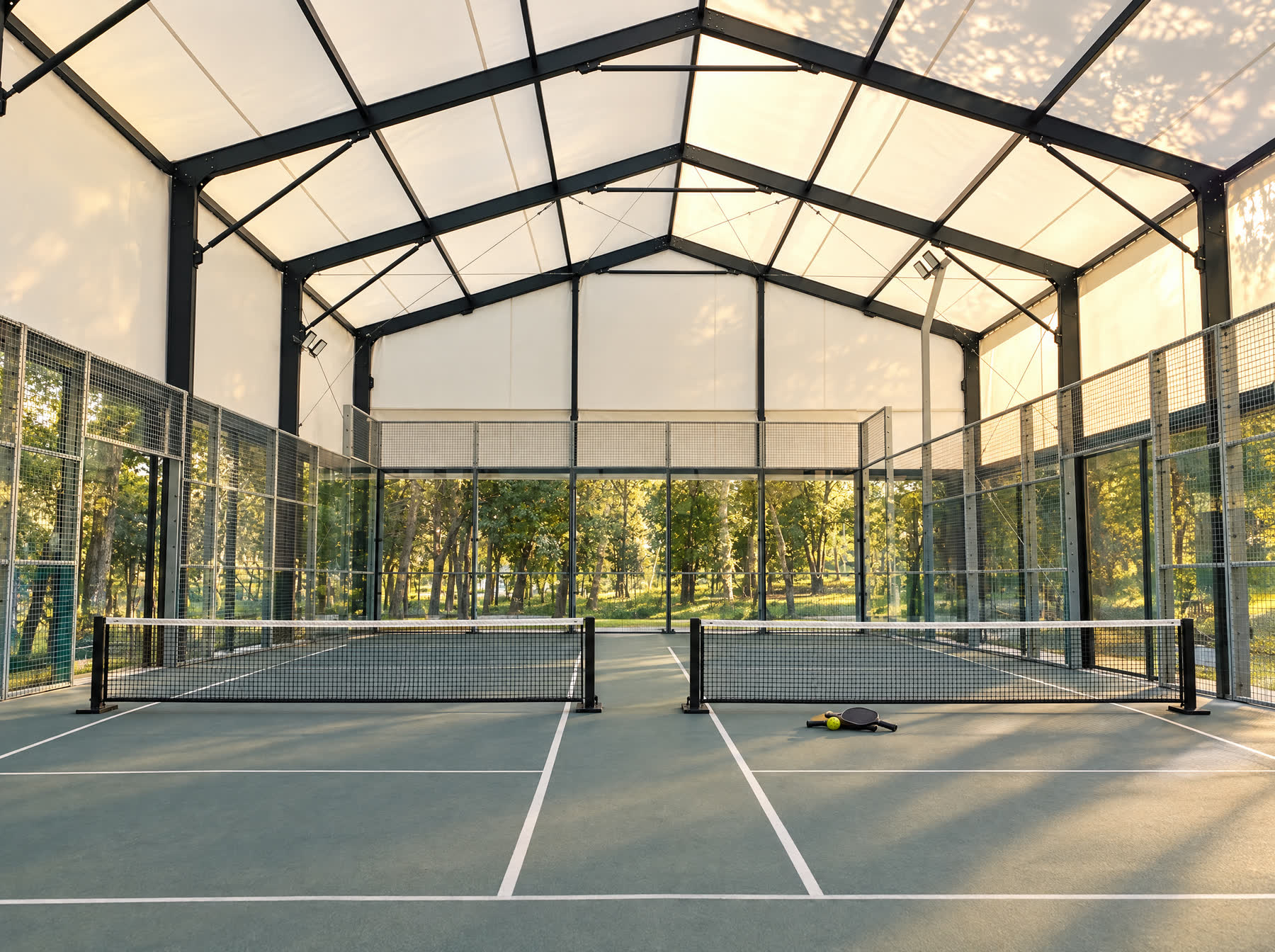 Two pickleball courts under the same canopy